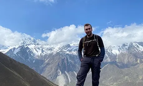 student in front of mountain