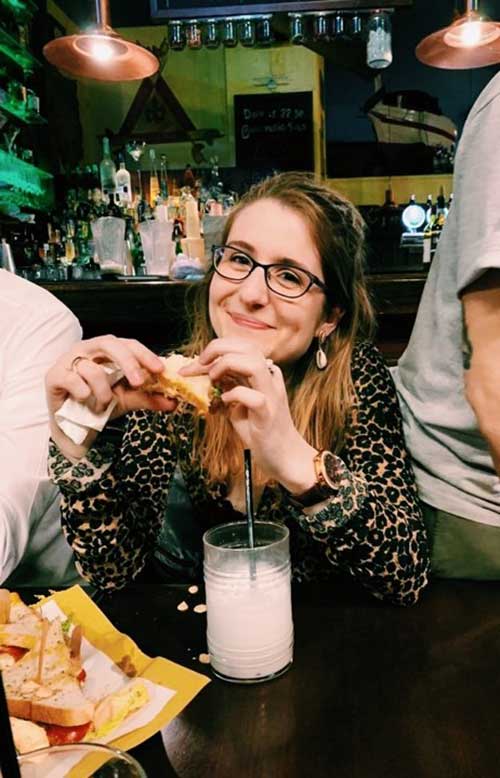 Camille Hanotte eating a sandwich in a bar in Milan