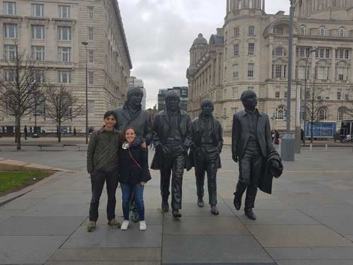 Juan Felipe Alvarez and a friends stood next to The Beatles statue in Liverpool
