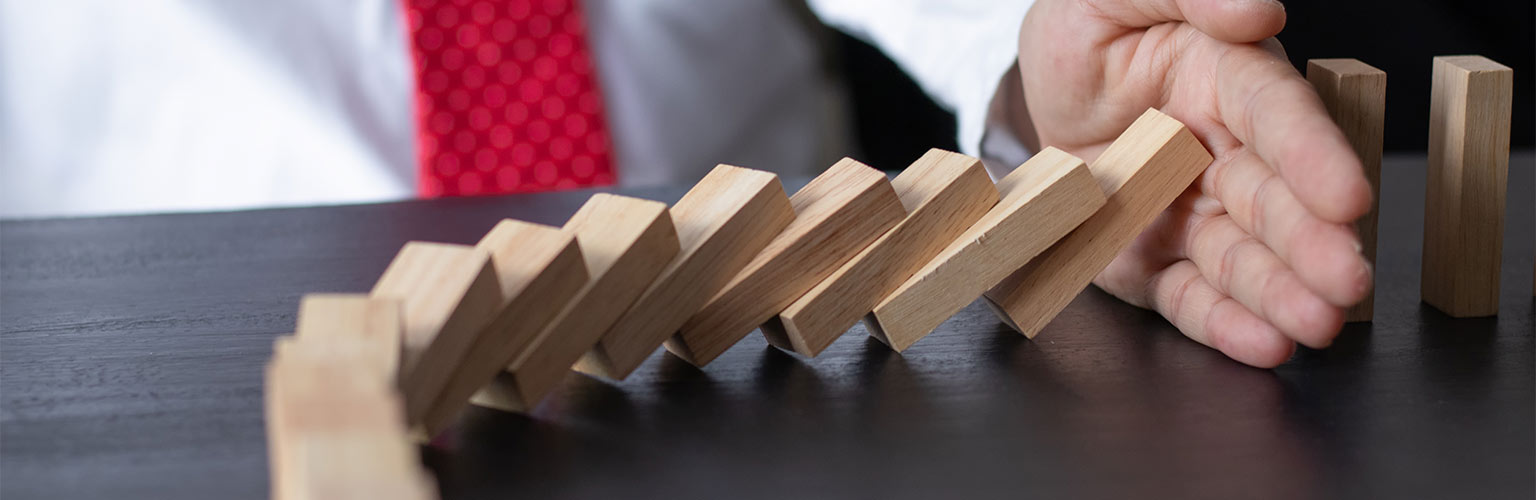 a businessman stopping domino effect