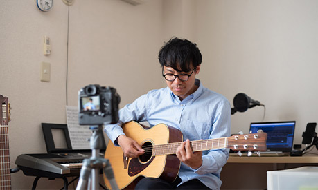 A man recording a song on his guitar