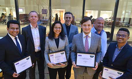 MBA competition winners holding certificates