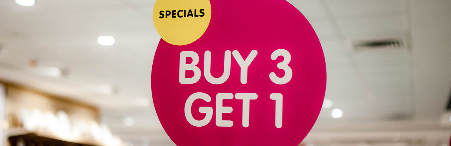 A pink marketing "buy 3, get 1" sign