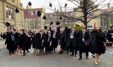 AMBS students celebrating their graduation in the Old Quadrangle at the University of Manchester